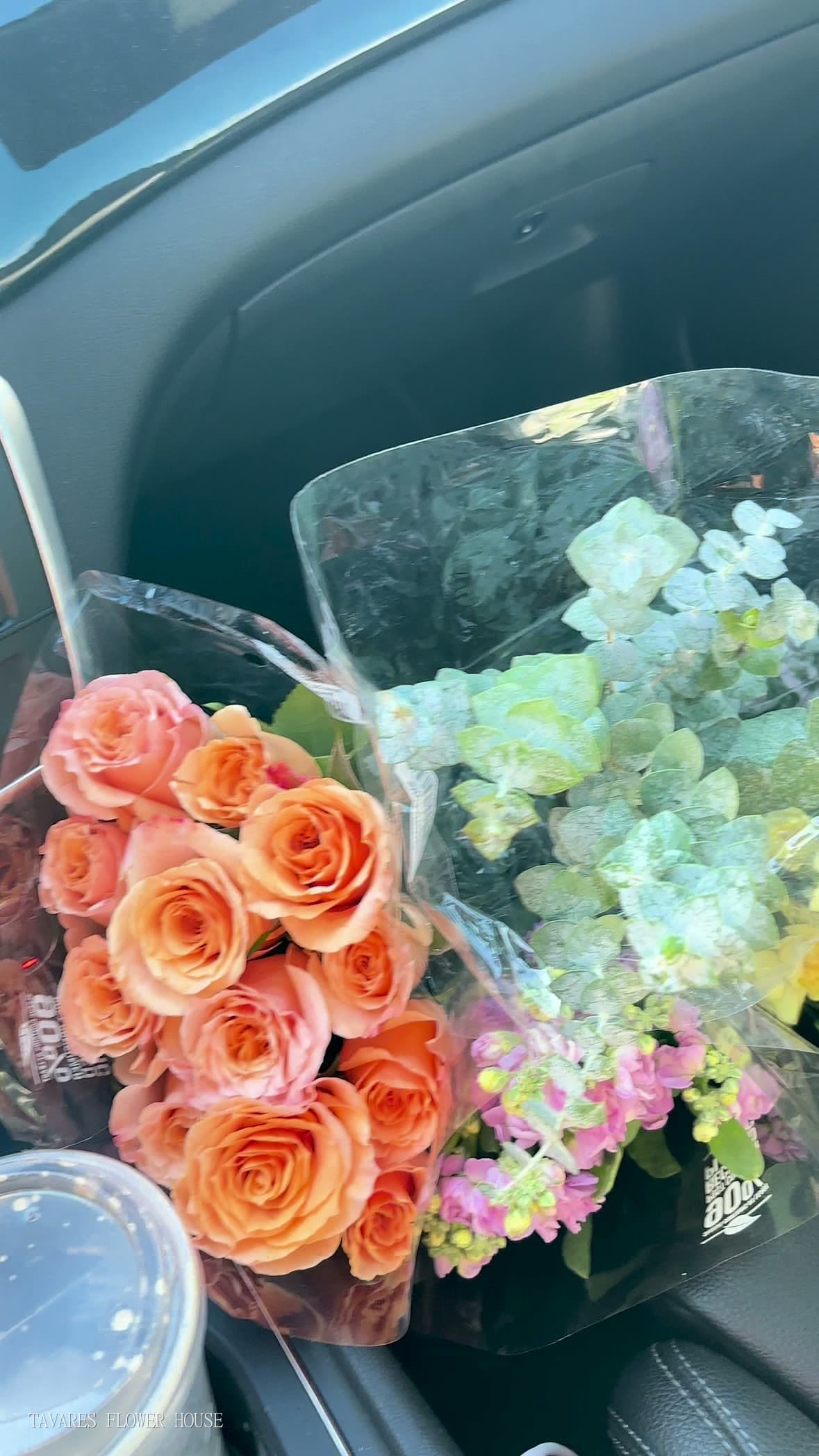 Peach roses, eucalyptus and pastel stems wrapped in sleeves, on their way back to the studio