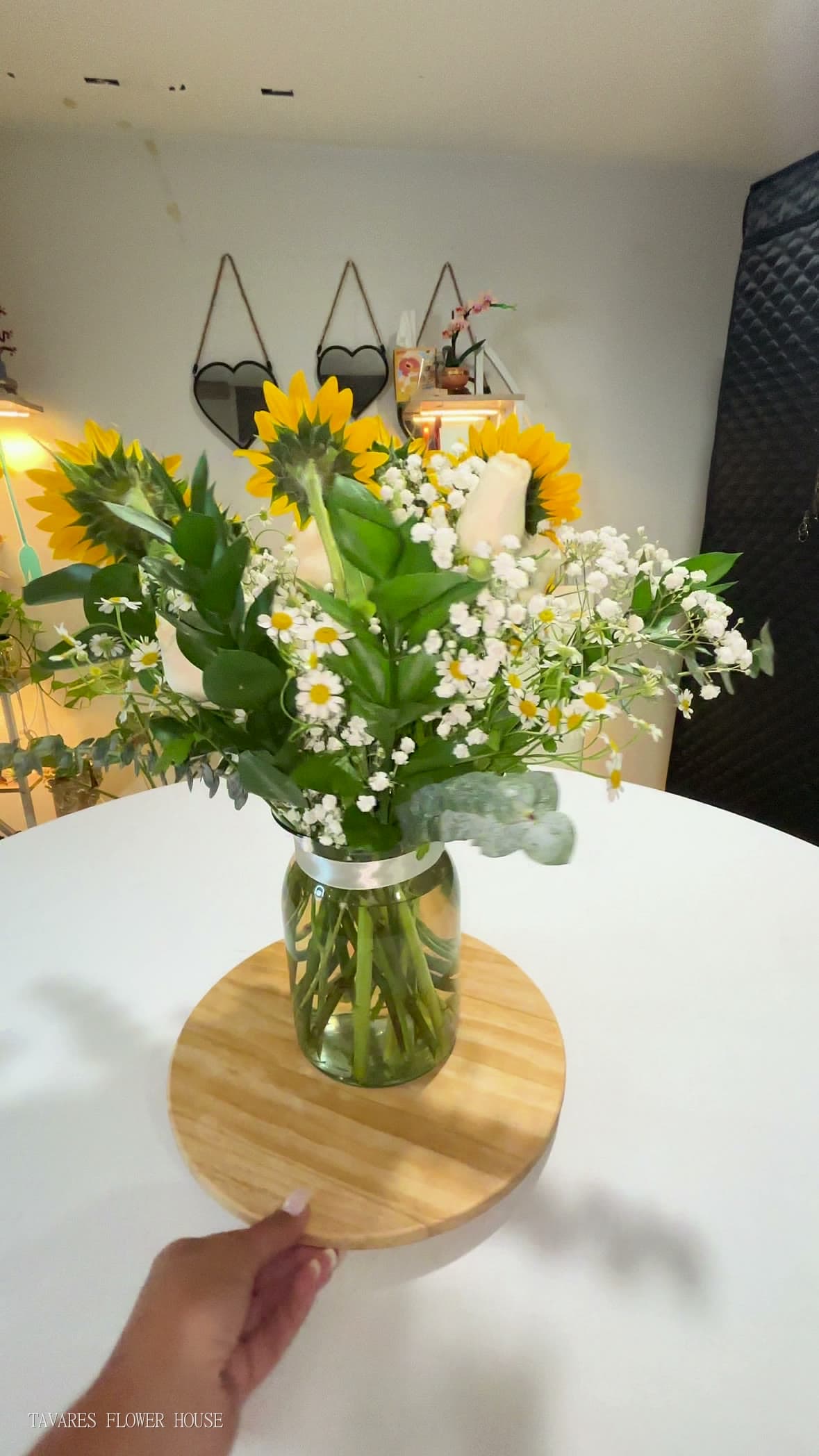 Sunflowers, white chamomile and eucalyptus arranged in a clear glass vase